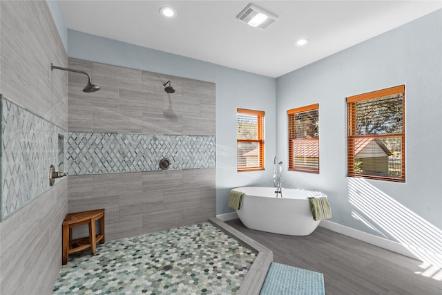 bathroom featuring hardwood / wood-style floors and plus walk in shower