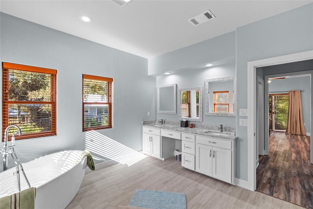 bathroom featuring hardwood / wood-style flooring, vanity, and a bathing tub