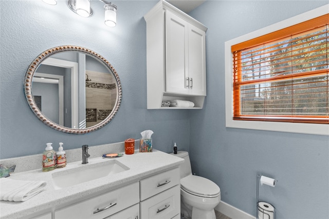 bathroom featuring toilet, a shower, and vanity