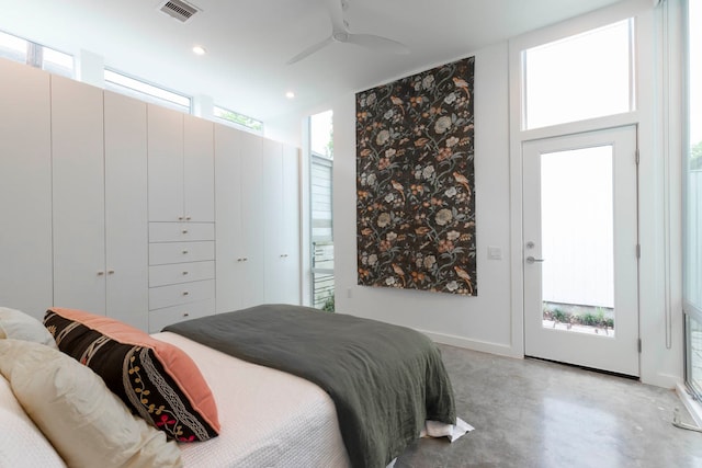 bedroom featuring access to outside, multiple windows, ceiling fan, and concrete floors