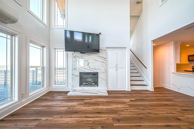 unfurnished living room with dark wood-type flooring and plenty of natural light