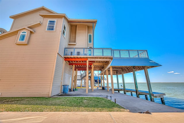 view of dock with a deck with water view and a yard