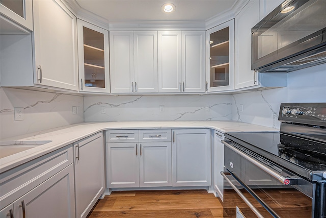 kitchen featuring light hardwood / wood-style floors, white cabinetry, and electric range