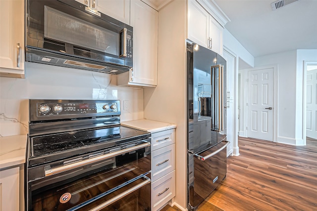 kitchen with white cabinets, black appliances, and dark hardwood / wood-style floors