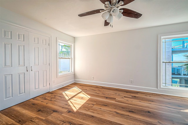 unfurnished bedroom with a closet, wood-type flooring, and ceiling fan