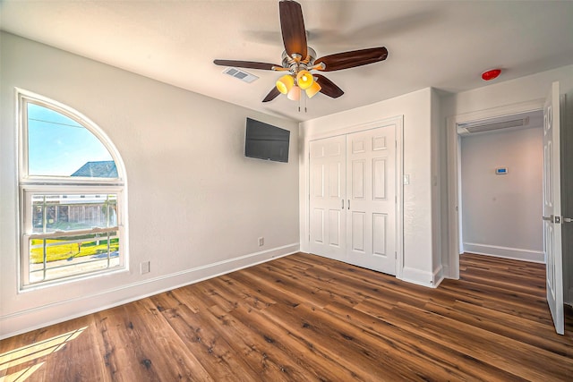 unfurnished bedroom featuring a closet, ceiling fan, and dark hardwood / wood-style floors