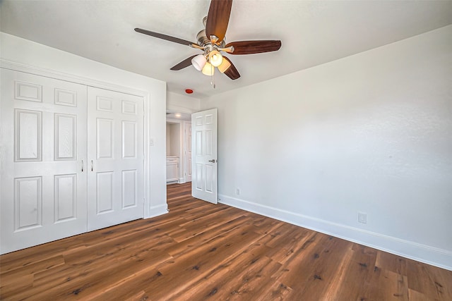 unfurnished bedroom with dark hardwood / wood-style flooring, a closet, and ceiling fan