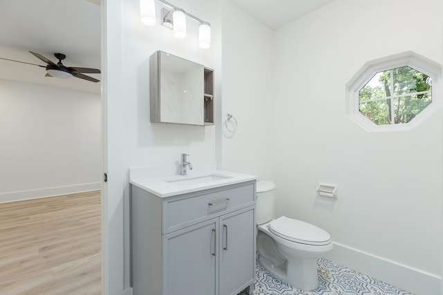 bathroom featuring vanity, hardwood / wood-style floors, toilet, and ceiling fan