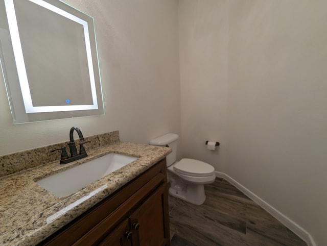 bathroom featuring hardwood / wood-style floors, vanity, and toilet