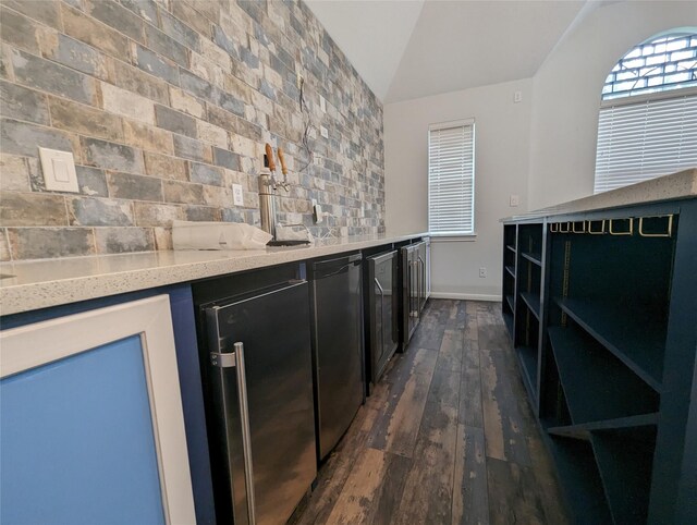 bar featuring stainless steel fridge, dark hardwood / wood-style floors, fridge, light stone countertops, and lofted ceiling