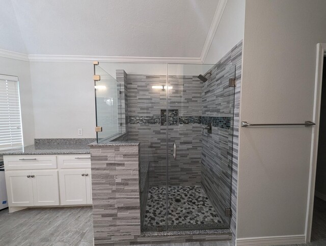 bathroom with vanity, walk in shower, crown molding, and vaulted ceiling