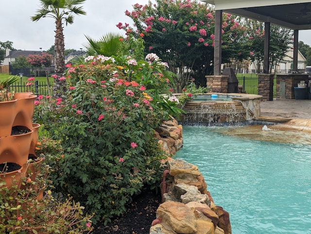 view of pool featuring an in ground hot tub and pool water feature