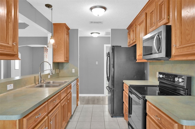 kitchen with stainless steel appliances, hanging light fixtures, a textured ceiling, sink, and light tile patterned floors