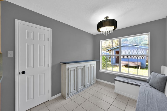 sitting room with a textured ceiling and light tile patterned floors