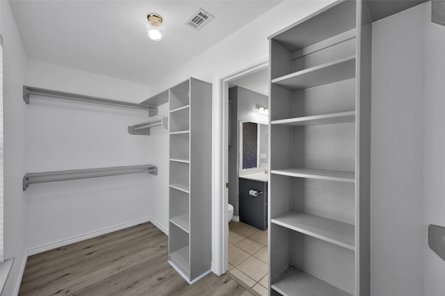 spacious closet with hardwood / wood-style flooring