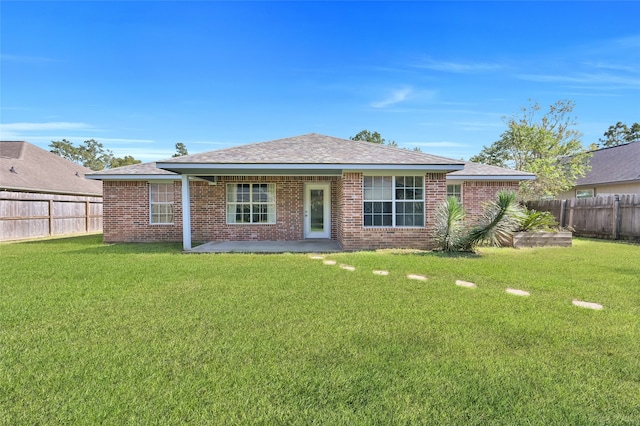 single story home featuring a front lawn and a patio