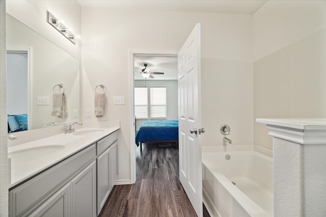 bathroom with a bath, vanity, and wood-type flooring