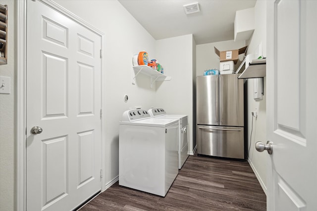 clothes washing area featuring washer and dryer and dark wood-type flooring