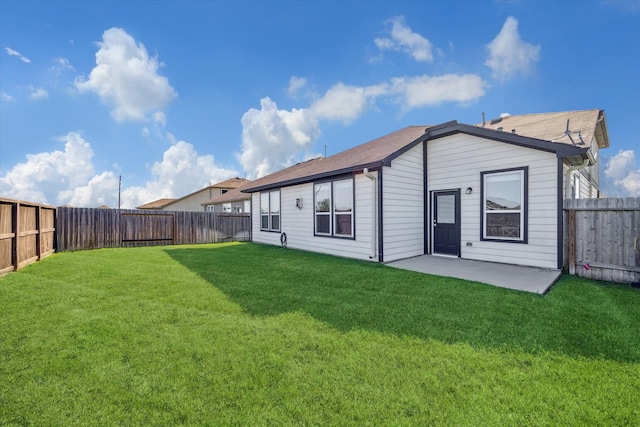 rear view of property with a yard and a patio