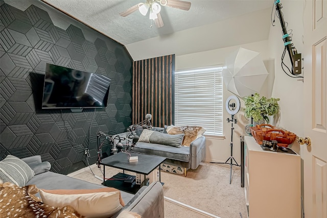 living room featuring ceiling fan, light colored carpet, and a textured ceiling