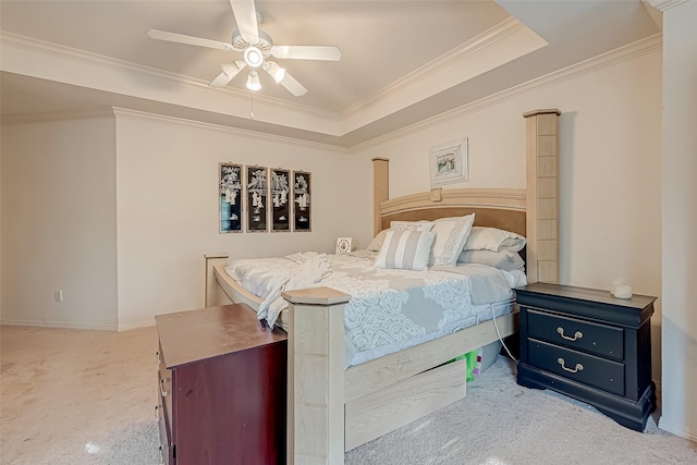 carpeted bedroom featuring ceiling fan, ornamental molding, and a tray ceiling