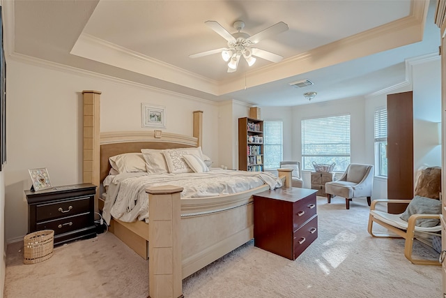 bedroom featuring a raised ceiling, light colored carpet, and ceiling fan