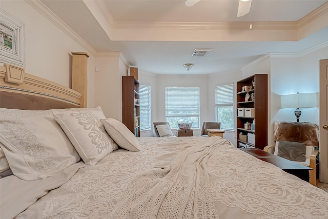 bedroom featuring ceiling fan, a tray ceiling, and ornamental molding