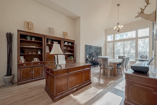 office featuring a high ceiling, a chandelier, and light hardwood / wood-style flooring