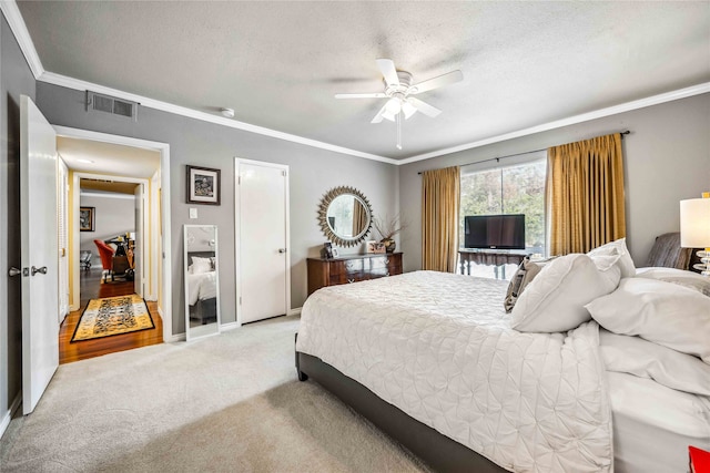 bedroom with ornamental molding, a textured ceiling, light carpet, and ceiling fan