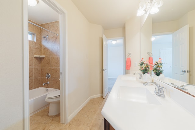 full bathroom featuring toilet, tiled shower / bath combo, vanity, and tile patterned flooring