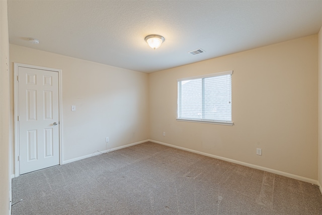 unfurnished room featuring a textured ceiling and carpet floors