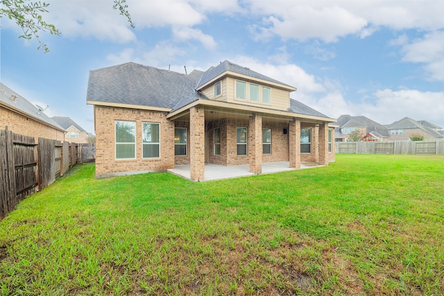 rear view of property featuring a lawn and a patio