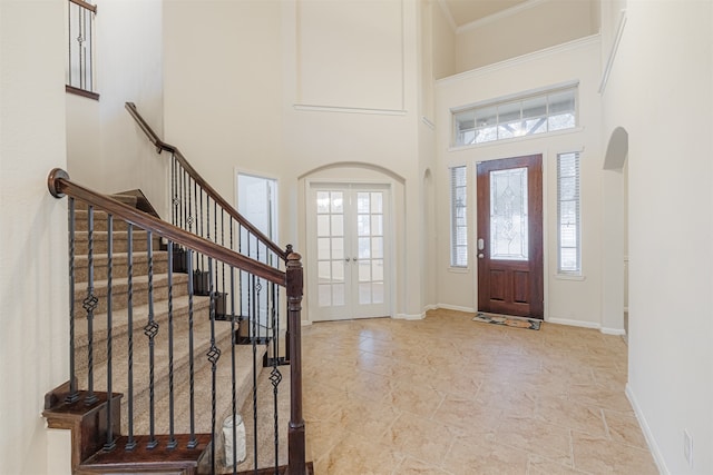 entrance foyer featuring a towering ceiling and french doors