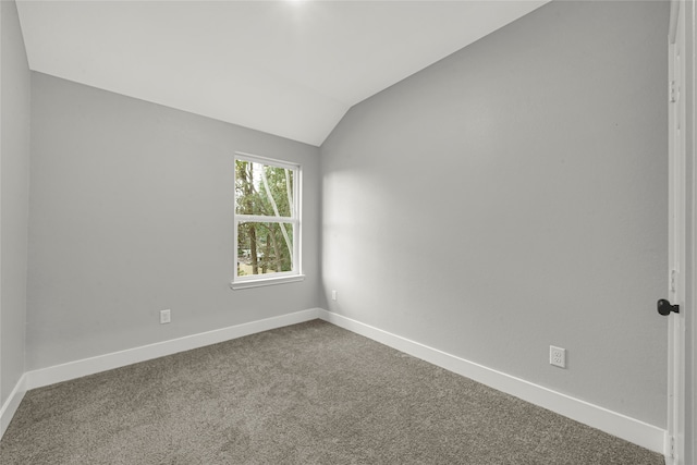 unfurnished room with carpet and vaulted ceiling