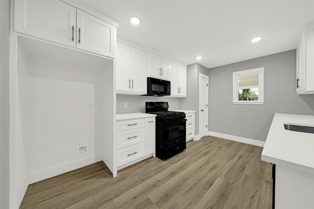 kitchen featuring black appliances, light hardwood / wood-style flooring, sink, and white cabinets