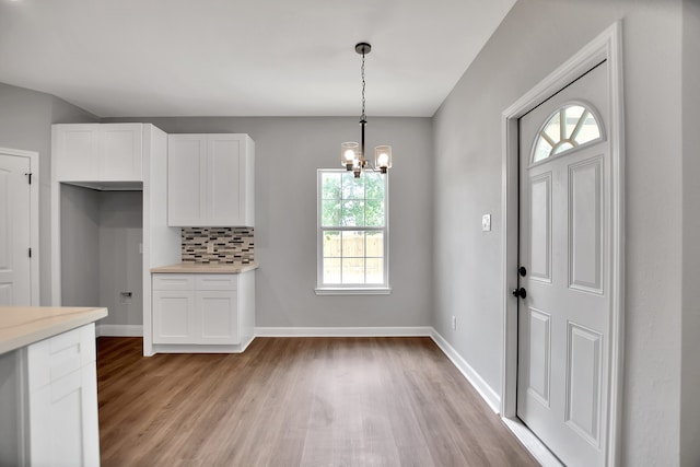 kitchen with white cabinets, plenty of natural light, and light hardwood / wood-style floors