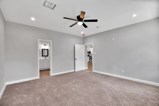 unfurnished bedroom with ensuite bath, light carpet, and ceiling fan