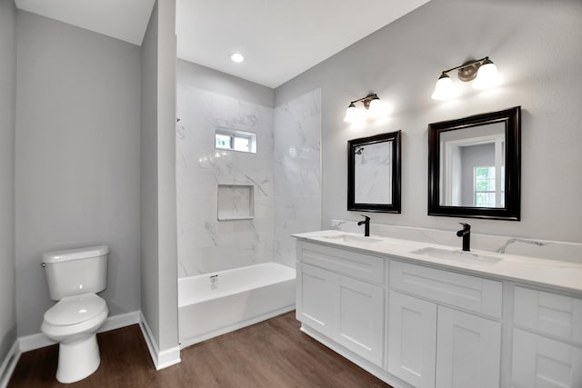 full bathroom featuring vanity, hardwood / wood-style flooring, toilet, and tiled shower / bath