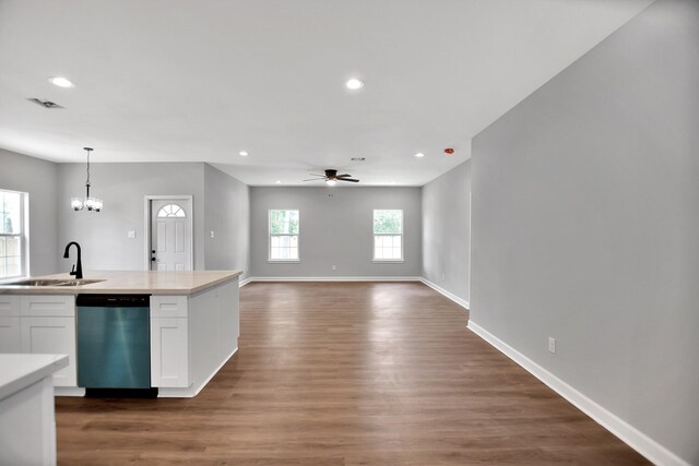 kitchen with dark hardwood / wood-style flooring, hanging light fixtures, sink, white cabinets, and dishwasher