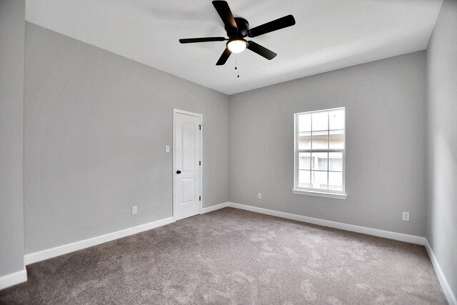 carpeted spare room featuring ceiling fan