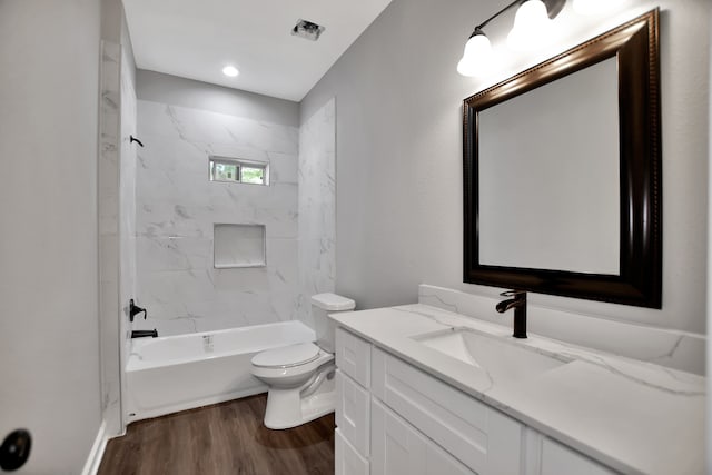 full bathroom featuring toilet, tiled shower / bath combo, vanity, and wood-type flooring