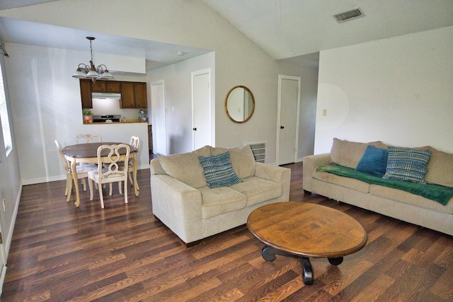 living room featuring dark hardwood / wood-style floors, vaulted ceiling, and a notable chandelier