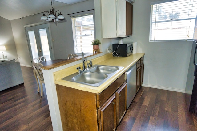 kitchen featuring stainless steel appliances, an inviting chandelier, hanging light fixtures, sink, and dark hardwood / wood-style floors