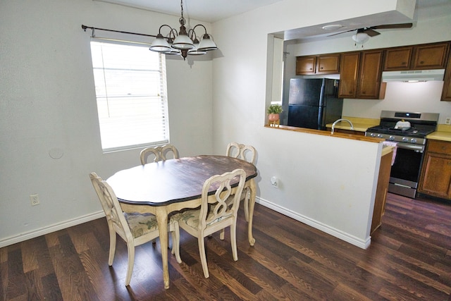 dining area with ceiling fan with notable chandelier, dark hardwood / wood-style floors, and sink