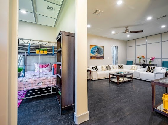 living room featuring ceiling fan and dark hardwood / wood-style flooring