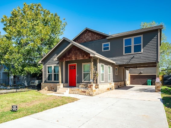 craftsman house with a front lawn and a garage