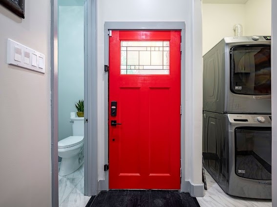 washroom featuring stacked washer / drying machine