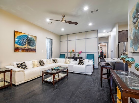 living room featuring dark wood-type flooring and ceiling fan