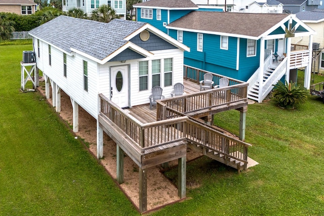 rear view of house featuring cooling unit, a yard, and a wooden deck