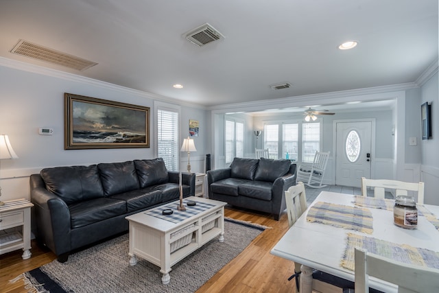 living room with ornamental molding, light wood-type flooring, and ceiling fan